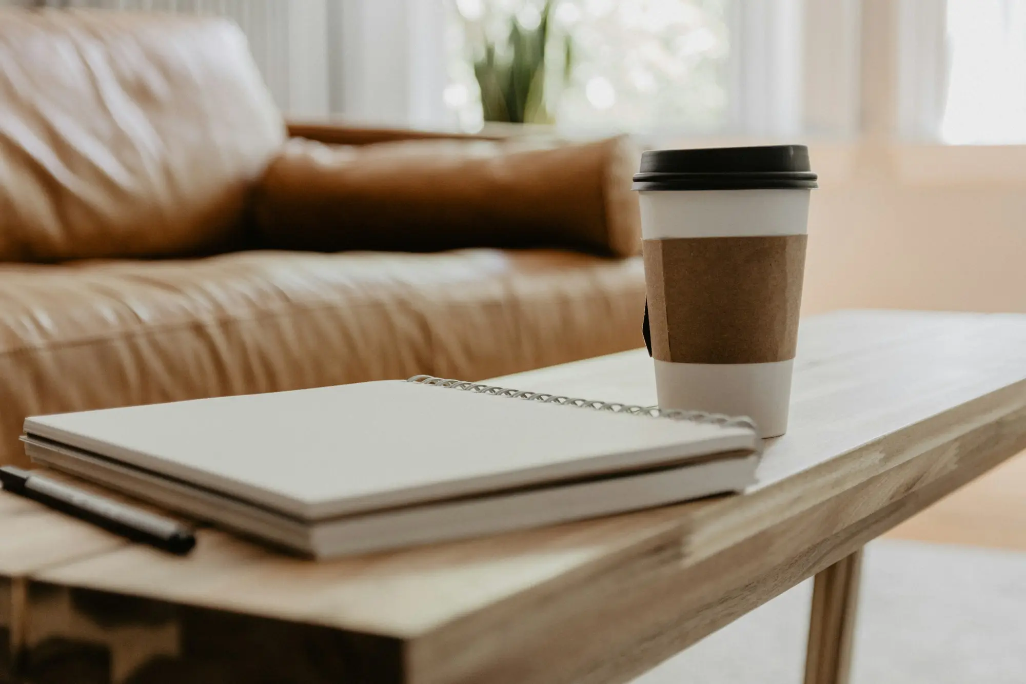 Coffee cup resting on an open notebook page beside a checklist