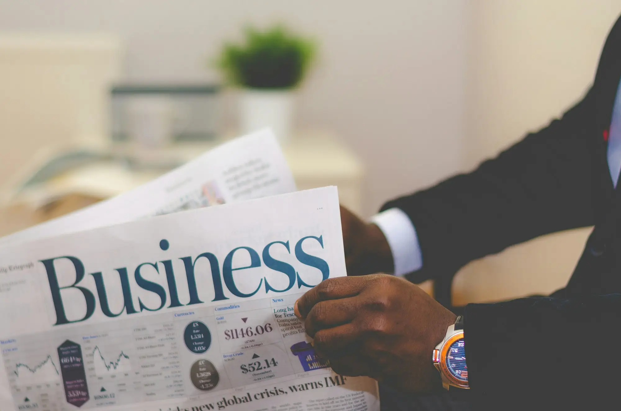 Company director in a suit reading the business pages