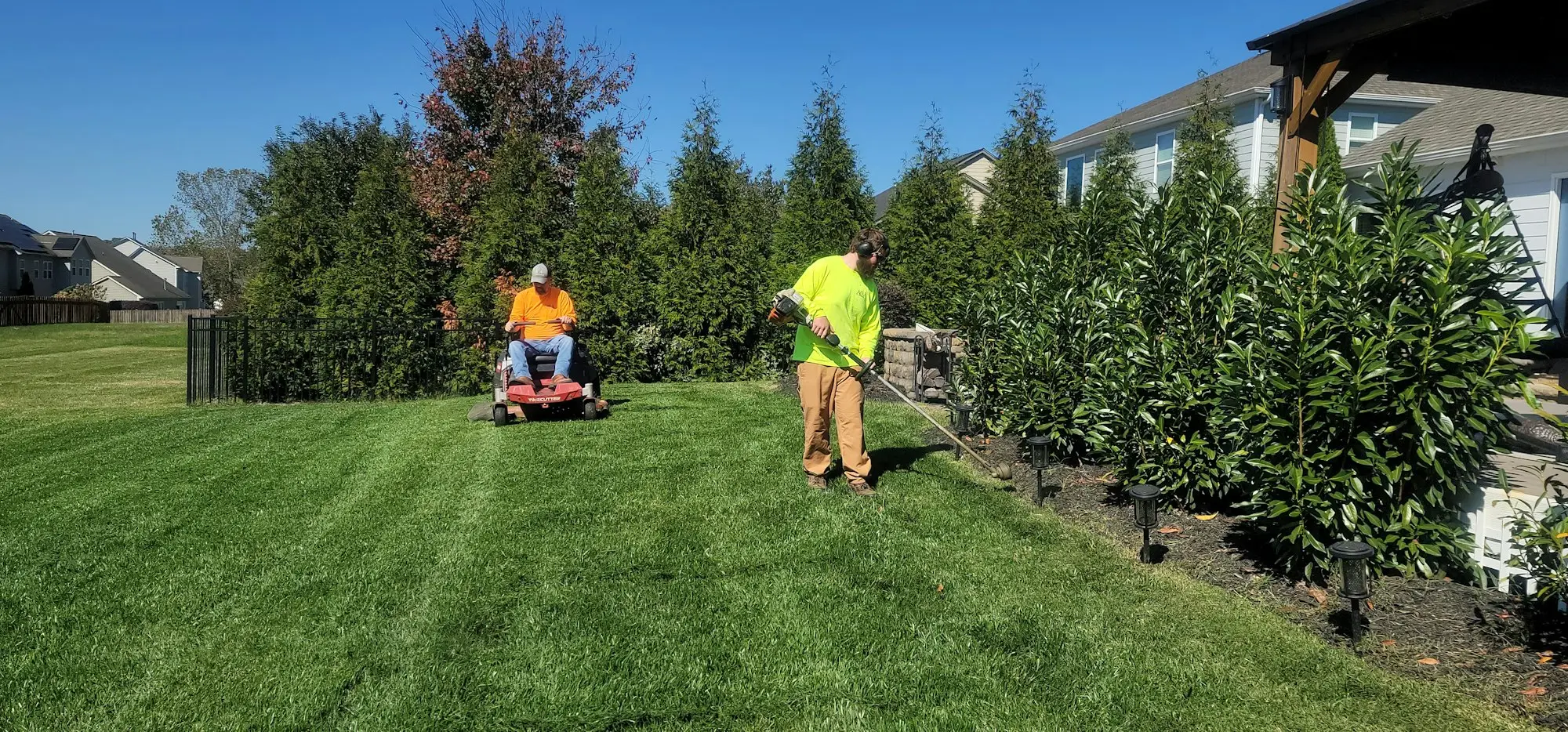 Gardener mowing a client lawn as part of a sole trader business