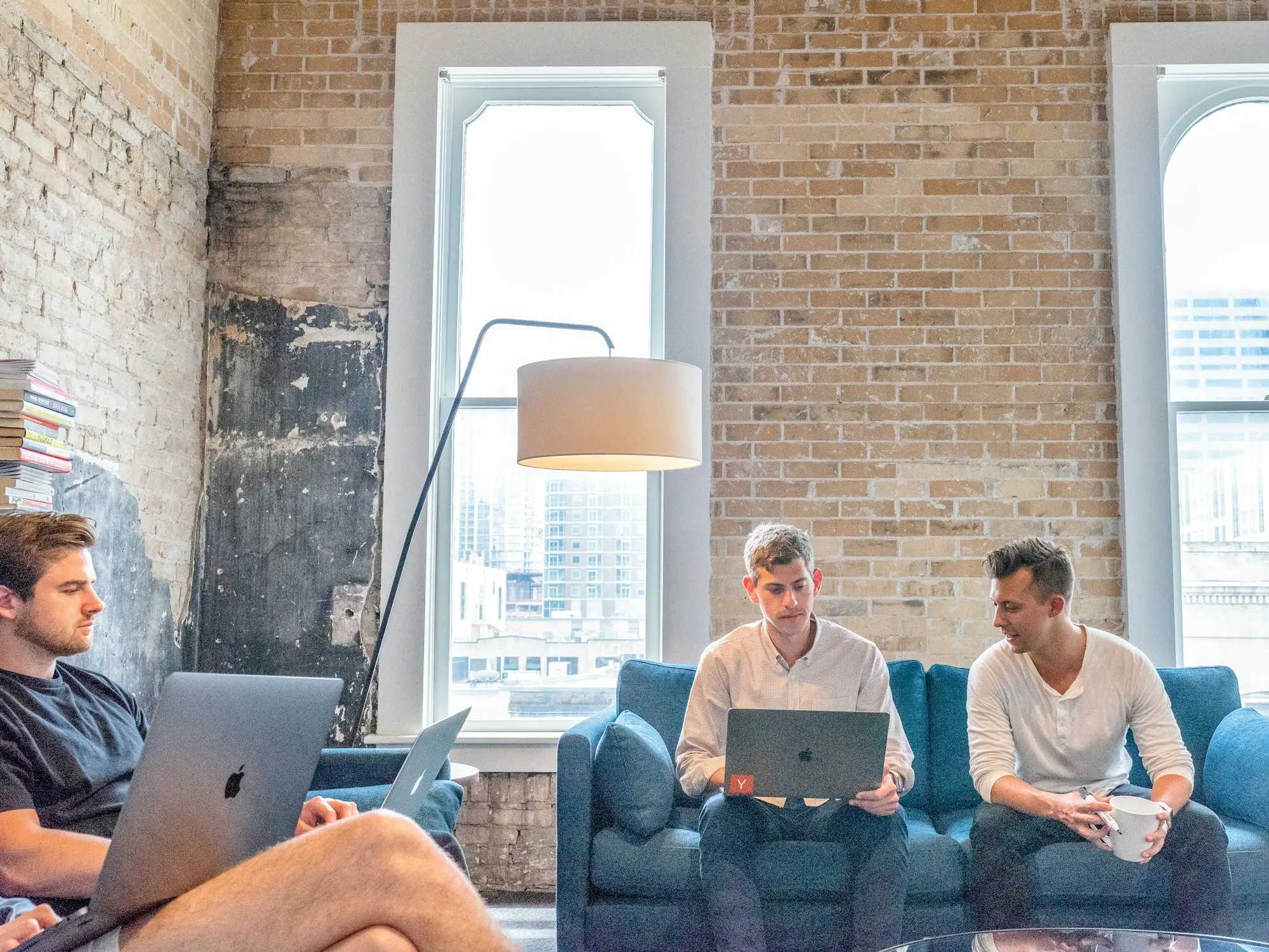 Three founders of a new business working on laptops