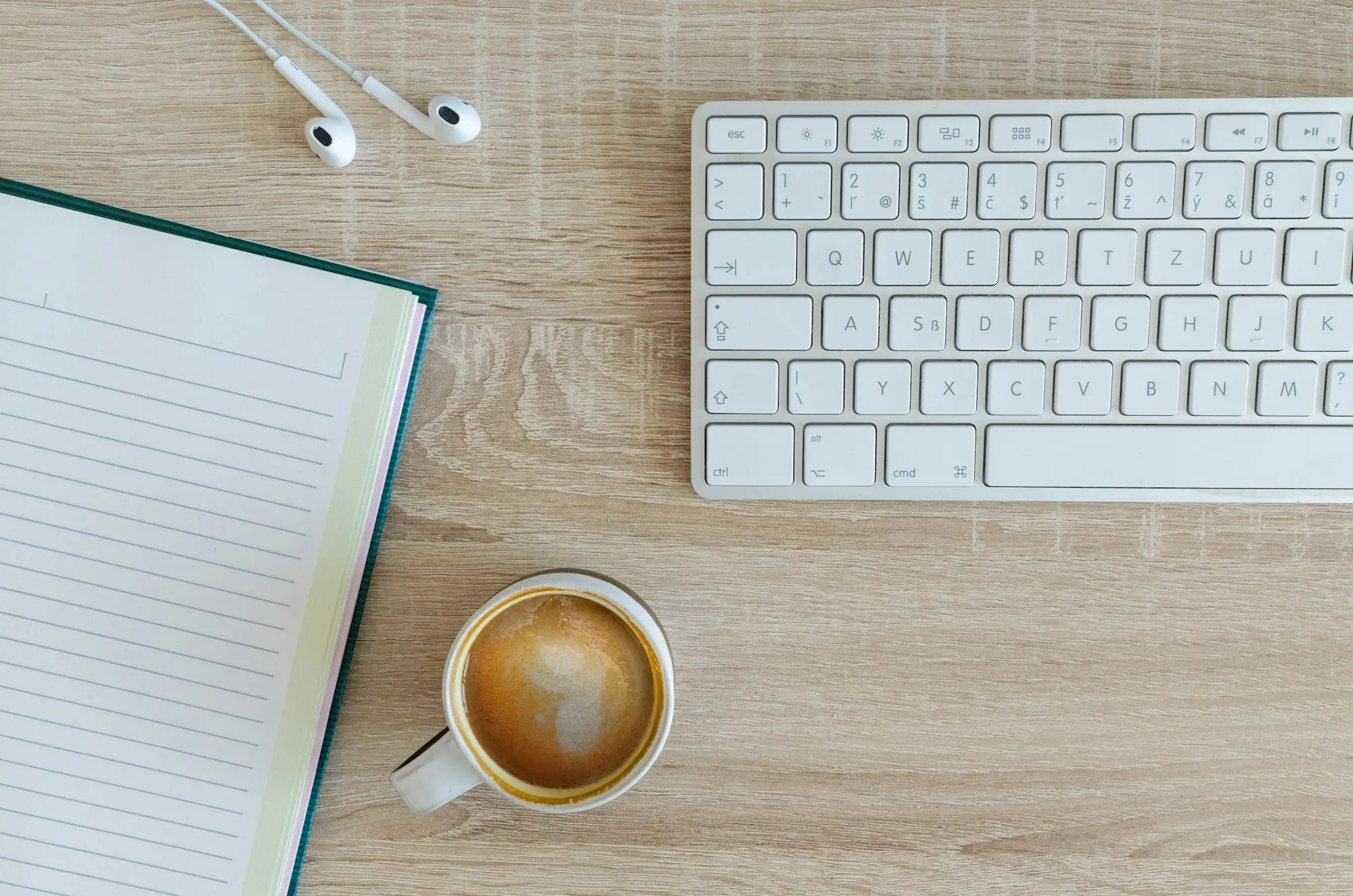 Coffee and a laptop keyboard on a desk, ready for an afternoon of business paperwork