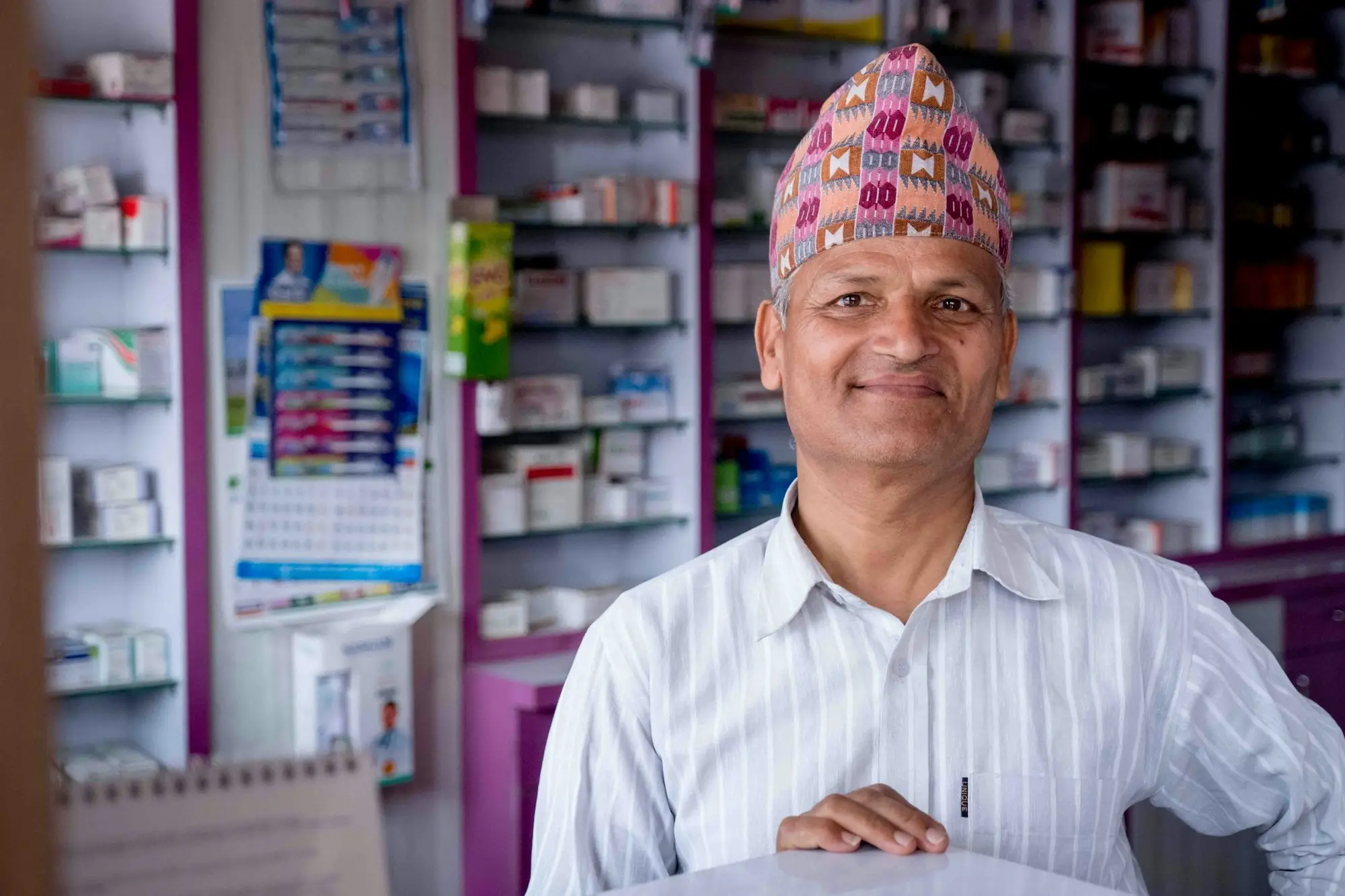 Pharmacy owner standing in his store holding a sheet of paper