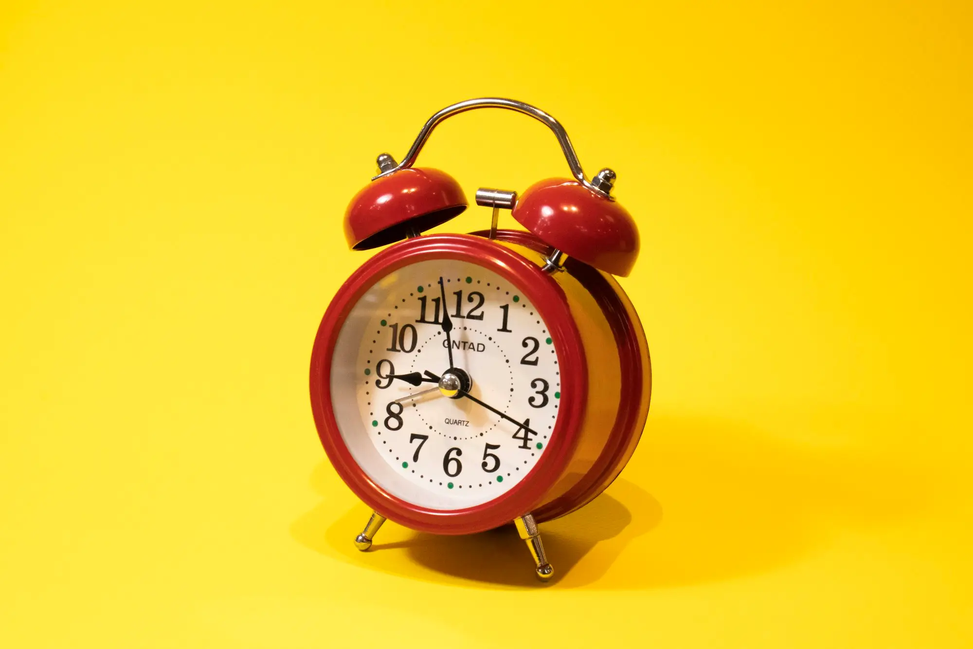 Red and white alarm clock on a plain background